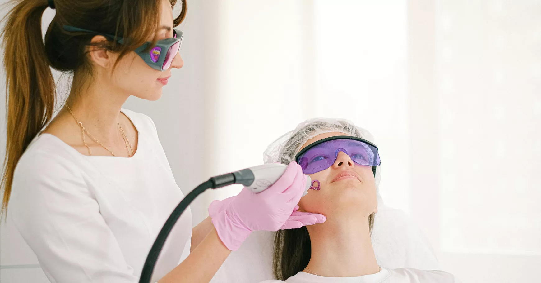 Especialista aplicando un tratamiento facial Lunchtime con dispositivo de luz pulsada a una paciente recostada